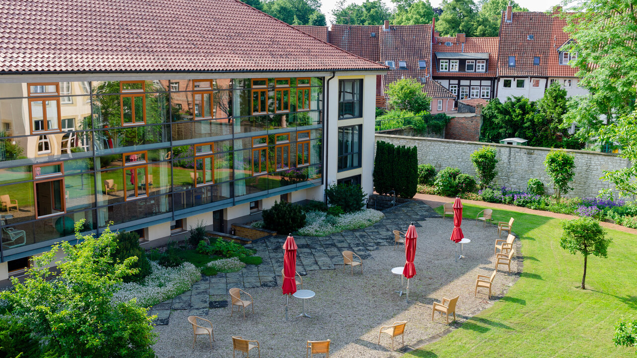 LÜCHTENHOF - Überblick über den Hofgarten, der sich in den Fenstern des Neubaus spiegelt